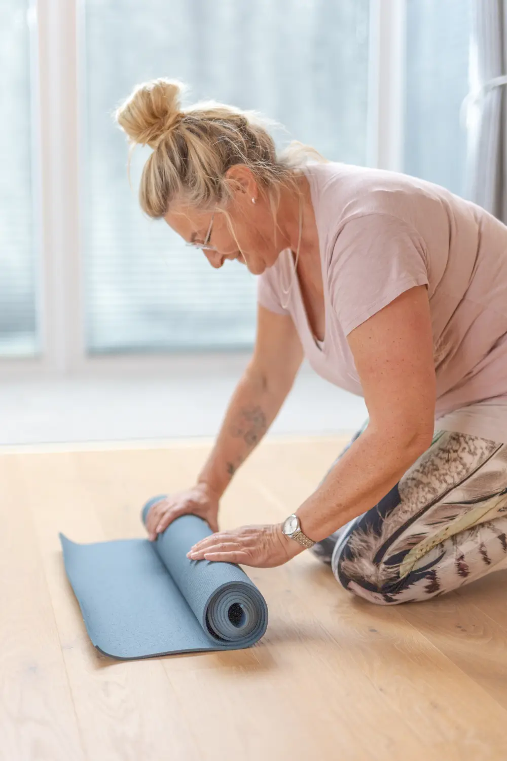 Anke Albrecht – Coach – Frau faltet Yogamatte